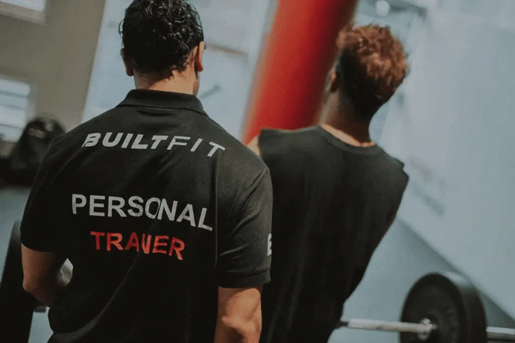 Home personal trainer guiding client workout session in Dubai apartment gym