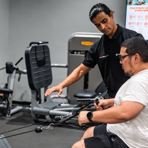 Beginner learning gym exercises with personal trainer